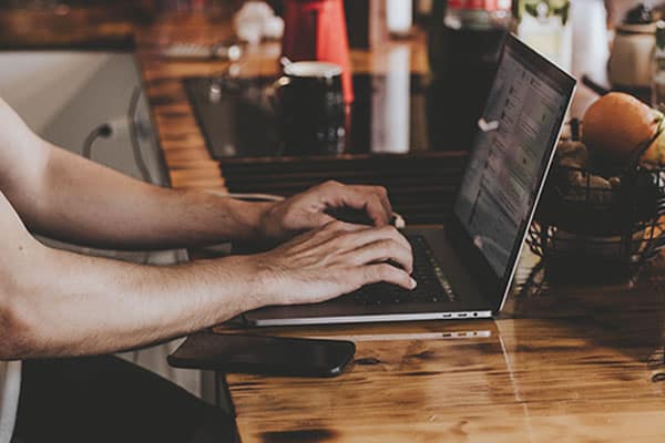 person working on a laptop on a coffee bar